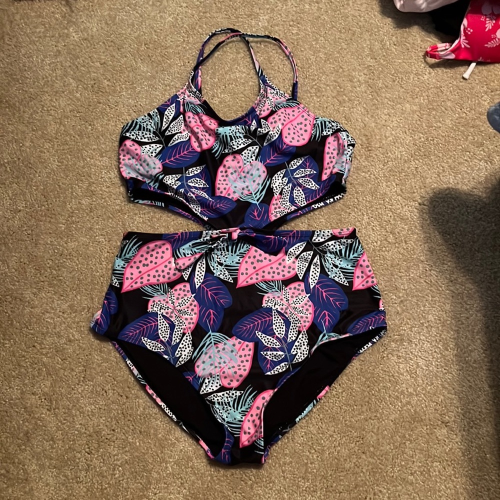 A swimsuit with a dark colored floral pattern